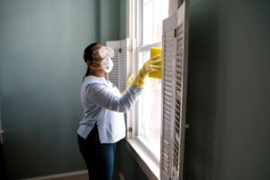 woman cleaning accumulated dust particulates with a damp sponge