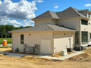 Side view of a modern residential building under construction with electrical panels and utility boxes