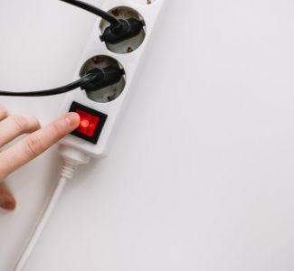 woman turns on an electric surge protector
